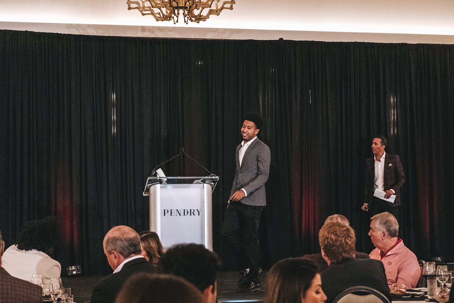 Desai Lopez speaking at a podium